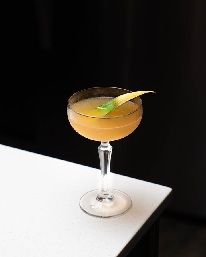 daiquiri in a couple glass with a pineapple leaf garnish