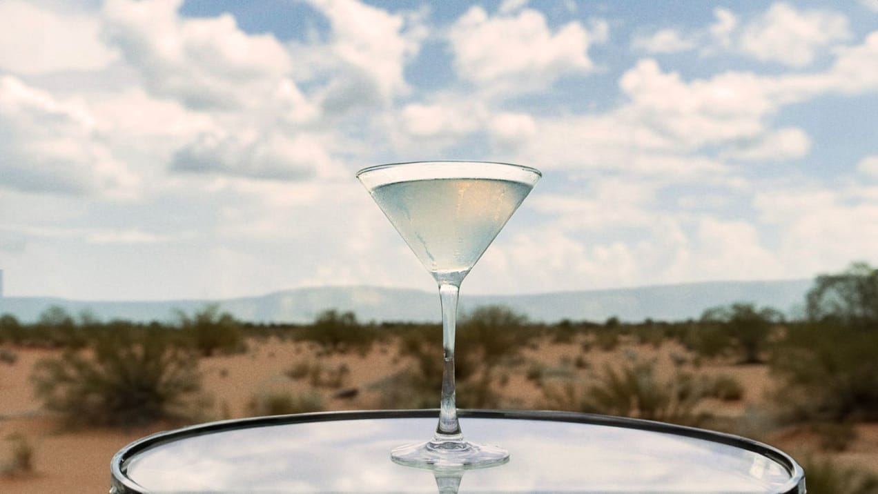 a shot of a Martini cocktails in the background of the Arizona desert.